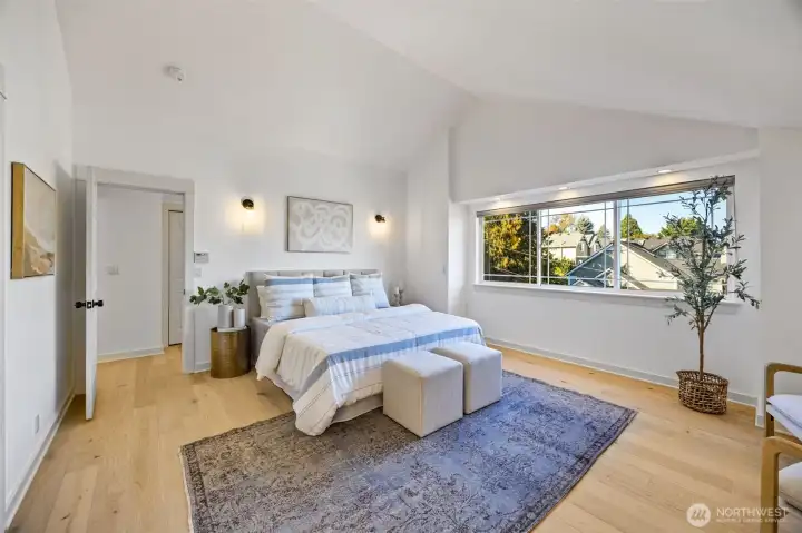 Generously sized primary bedroom with vailted ceilings, walk in closet, and en-suite bathroom