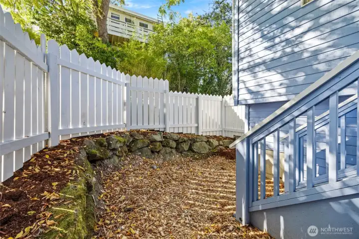 Wonderful covered porch off main level dining area features stairs to the small fenced outdoor space