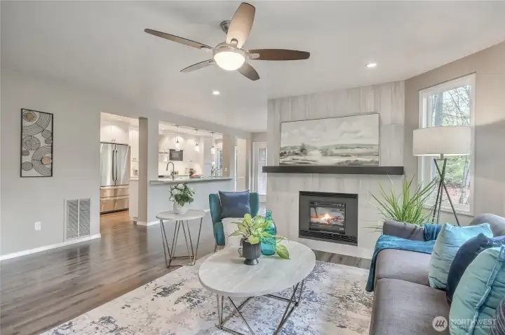 Beautiful living room, kitchen and dining room with just enough separation to fully appreciate the spaces. Fire is app generated.