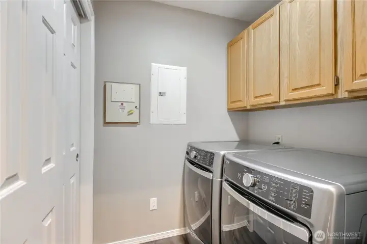 Utility room with newer washer and dryer, storage and sliding door for separation from kitchen.