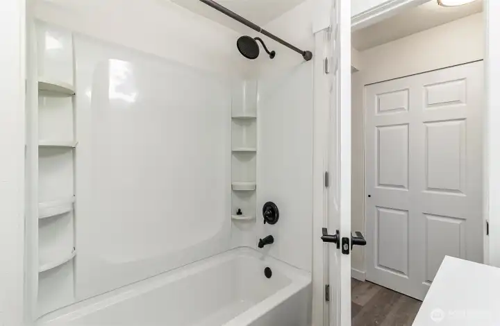 Large tub/shower with built in shelves, sleek and new