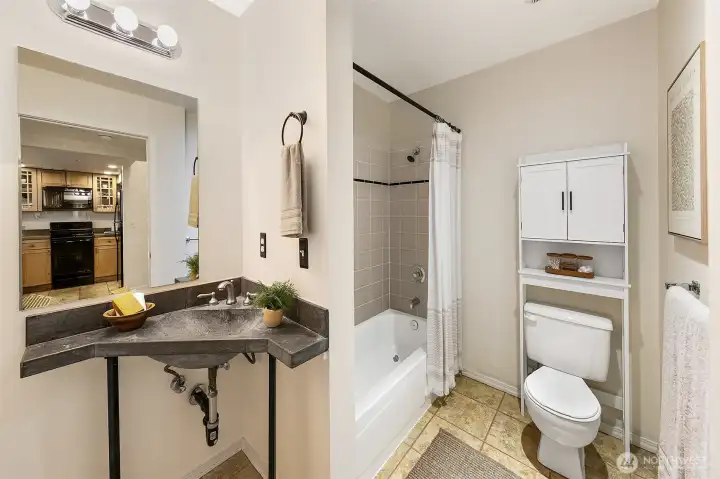 Main floor full bathroom with built in storage and concrete counters