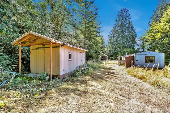 Shed on left is in good shape. Manufactured home on property is a tear-down, DO NOT attempt to enter. This space is a good sized level area for a big rambler.