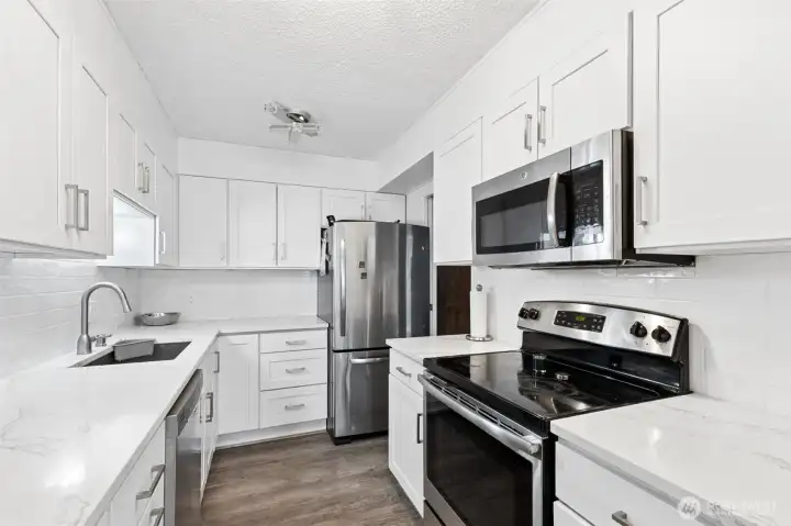 COMPLETELY remodeled kitchen- new cabinets, new countertops, new appliances, new LVP flooring.... pristine white with clean lines.