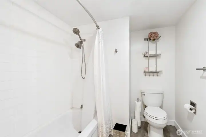 Primary suite full bathroom- NEW LVP flooring, new toilet, new tub with subway tile surround.