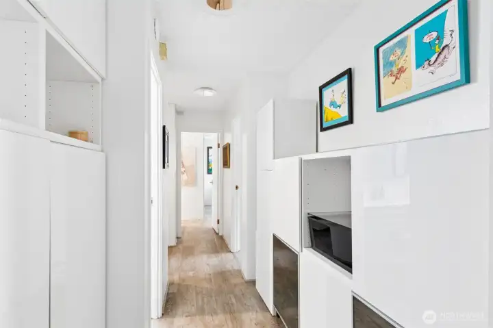 Hallway offers extra storage options with built in cabinets.