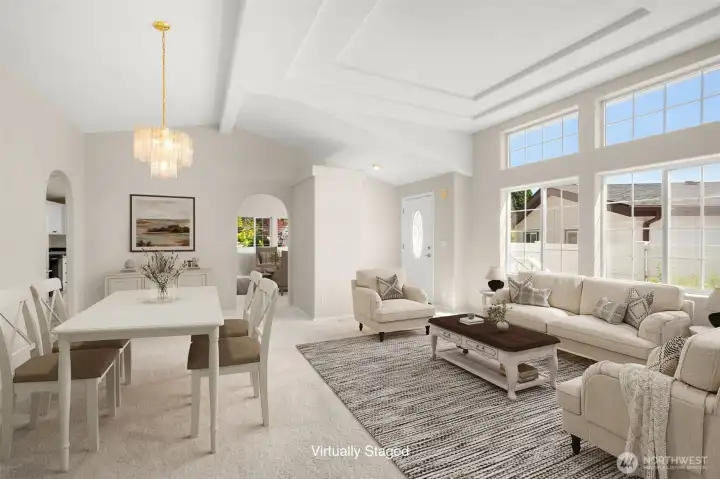 Virtually staged. Another angle of the large living room/formal dining area with cathedral ceilings.