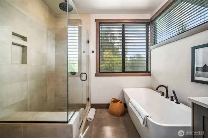 Whether you enjoy a deep soak in the tub at the end of your day or a warm shower - main floor primary en suite offers both in luxurious manner