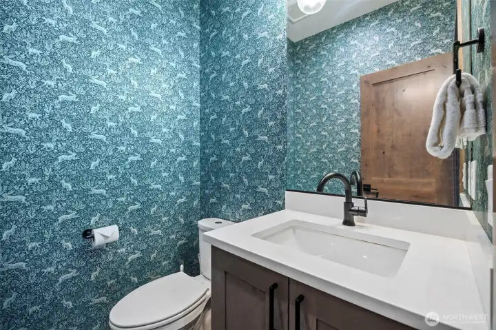 Adorable powder room for main floor convenience - have to love the bunny wallpaper, so sweet