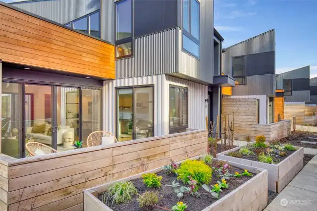 Charming planter boxes welcome you, offering an opportunity to cultivate your own garden oasis. Photo of model home, 228 Canopy Path, with upgraded landscaping.