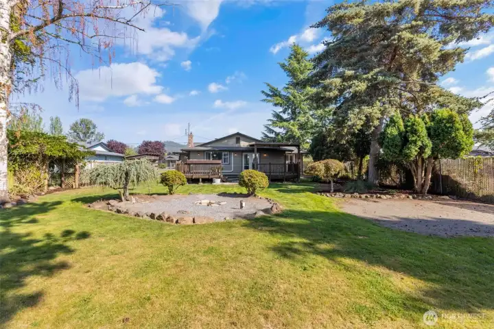 Beautifully landscaped backyard with mature trees and shubbery
