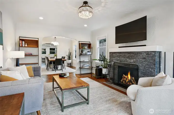 Warm and inviting living room with fireplace, hardwood floor leaded glass windows and coved ceiling.