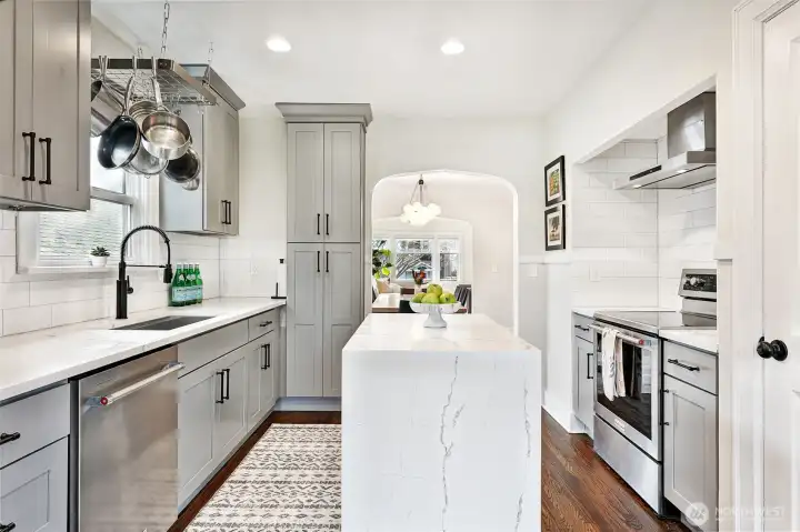 View from kitchen toward dining and living rooms. Extensive remodeling throughout the home with thoughtful details creating modern updates while also maintaining the original old world charm.