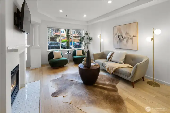 Main floor features open-concept kitchen and living area with abundant natural light, cozy gas fireplace, and powder room.