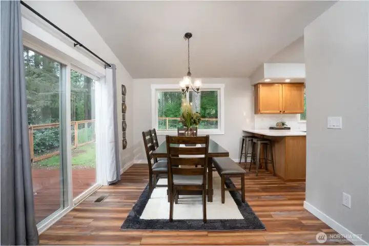 Dining room with views of the back yard -  refreshed kitchen to the right.