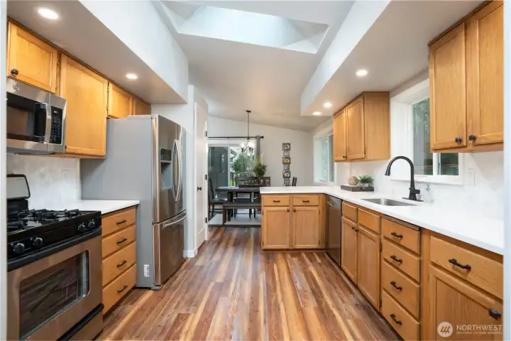 The kitchen has been thoughtfully updated with new quartz countertops, sink & faucet, custom tile backsplash, stainless steel appliances plus a slider that leads you to the private back deck and backyard.