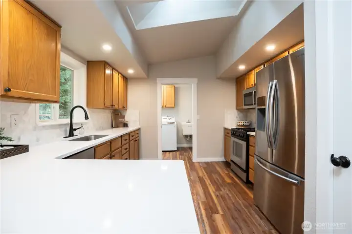 Another view of the kitchen and utility room beyond. The skylight lets in tons of natural light!