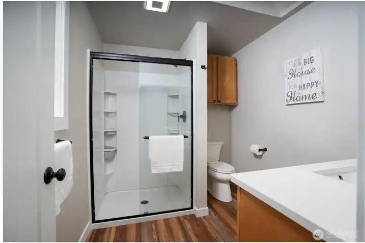 The primary ¾ bath with new vanity, quartz top, shower enclosure and lighting fixtures.