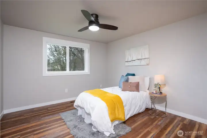 Bedroom one with lots of space, LVP flooring, new doors, mill work and ceiling fan.