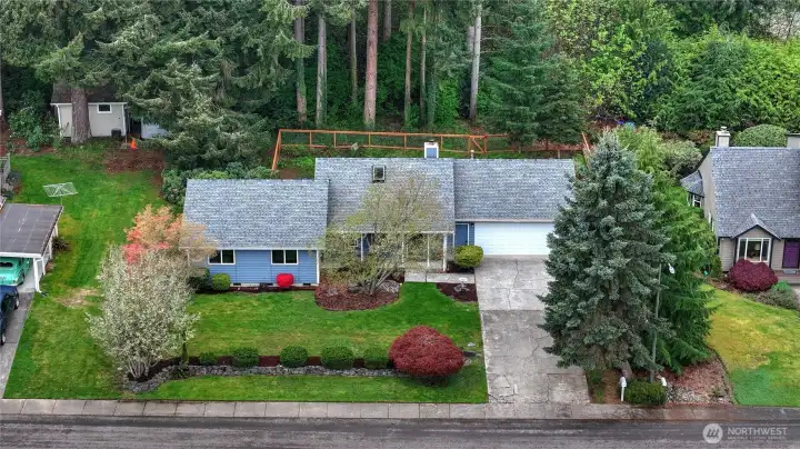 Drone shot of the the property, showing off the fenced backyard and the woodlands beyond that adds an extra level of privacy to your backyard oasis!