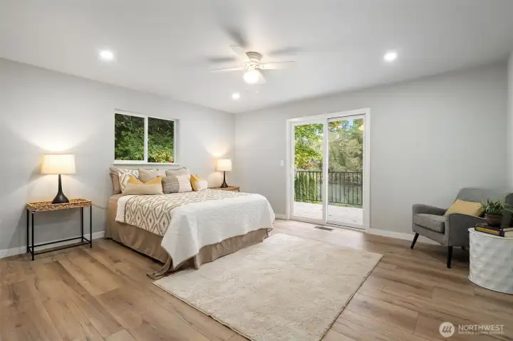 Primary bedroom with sliding glass door to large deck