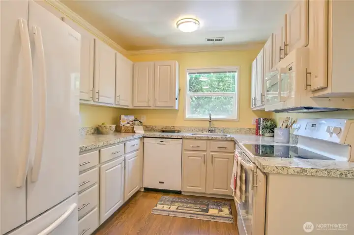 Sparkling newer kitcen features refaced cabinets, crisp white trim, pantry & newer microwave.