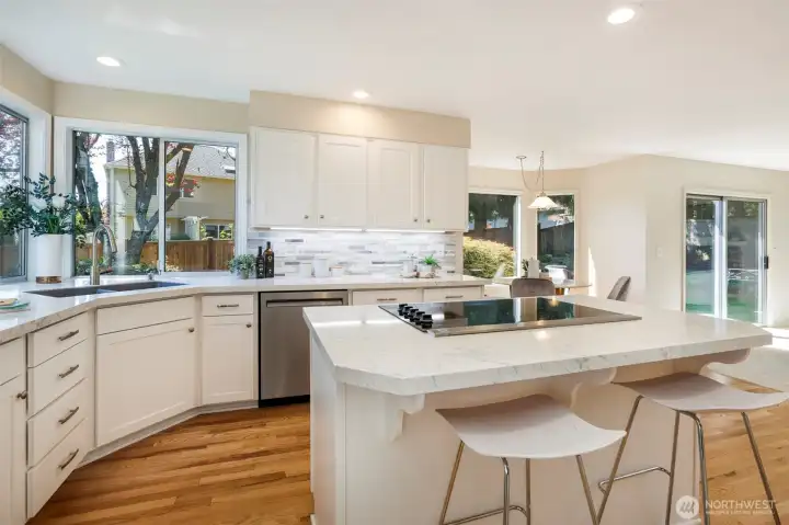 Step into modern, island kitchen w/ marble counters, deco-tile backsplash & Shaker-style  cabinets w/ undercounter lighting