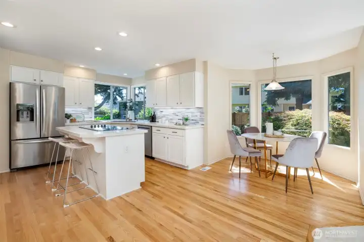 Large eating nook with bay windows + corner windows above sink lets the sunlight in & backyard views too