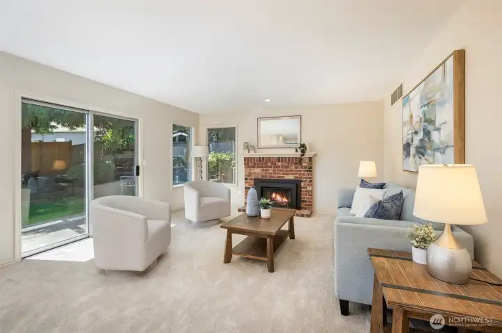 Bright family room w/ gas fireplace insert leads to backyard & patio areas