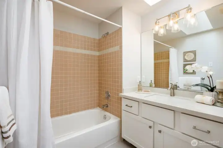 Upstairs skylit hall bath with upgraded vanity, marble top, new toilet & vinyl floor