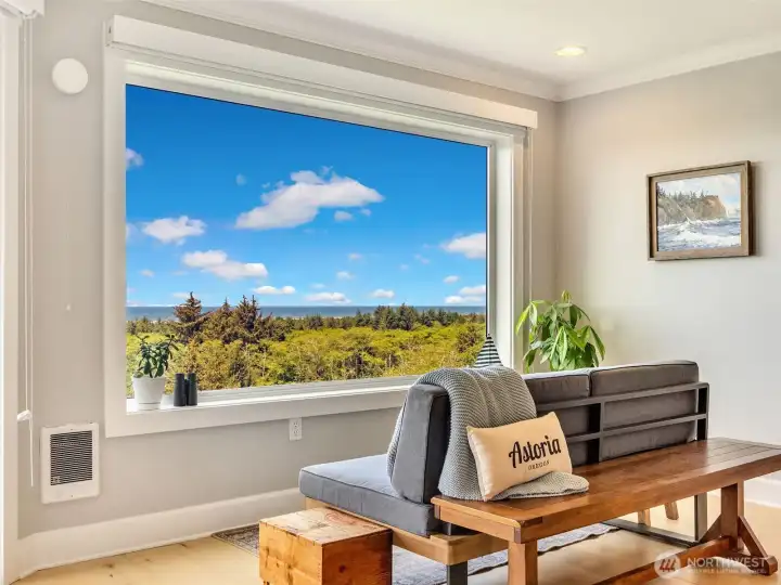 Picture window frames breathtaking views of the Pacific coastline and surrounding natural beauty.