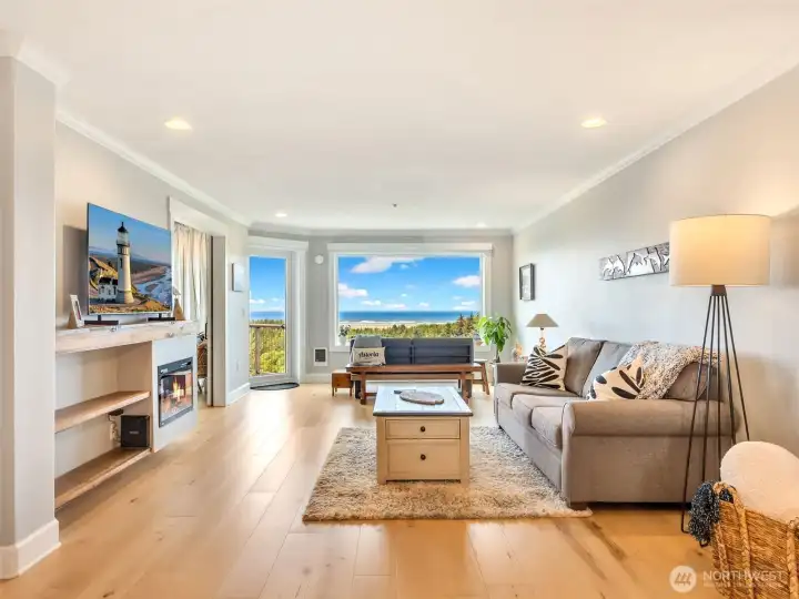 Spacious living room with expansive windows showcasing stunning Pacific Ocean and peninsula views.