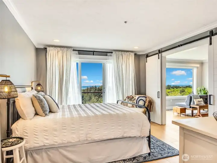 Spacious primary suite featuring abundant natural light and peaceful coastal views.