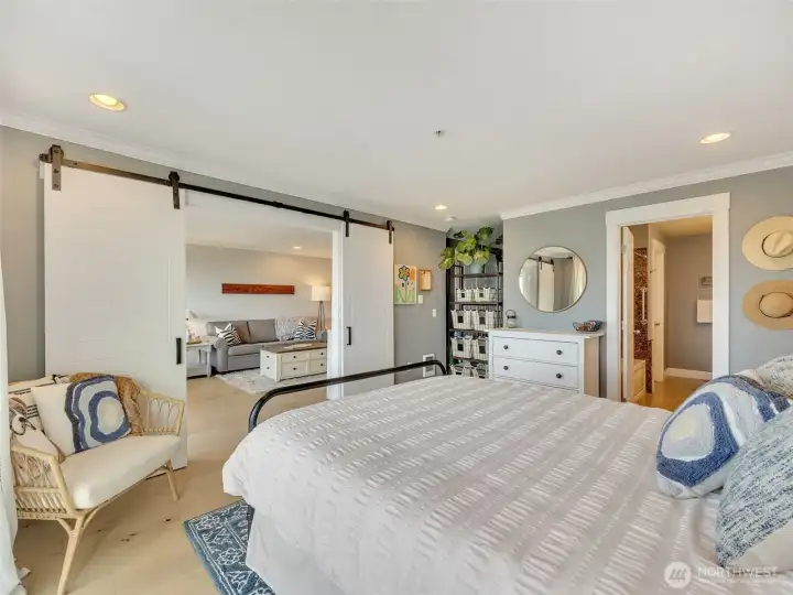 Large primary suite overlooking the open living space, creating an airy and inviting feel.