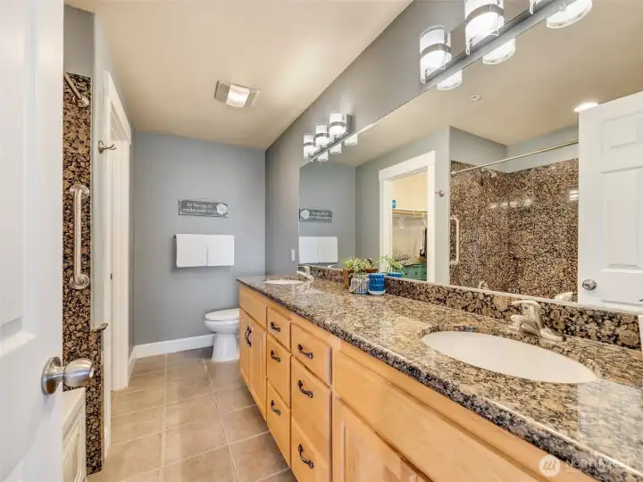 Ensuite bathroom features dual vanities, granite countertops, and plenty of storage.
