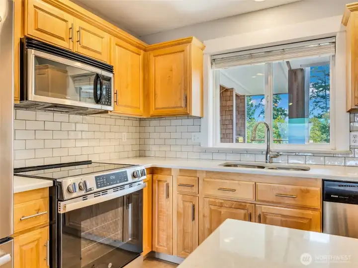 Well-equipped kitchen offers plenty of prep space, modern appliances, and views toward the surrounding landscape.