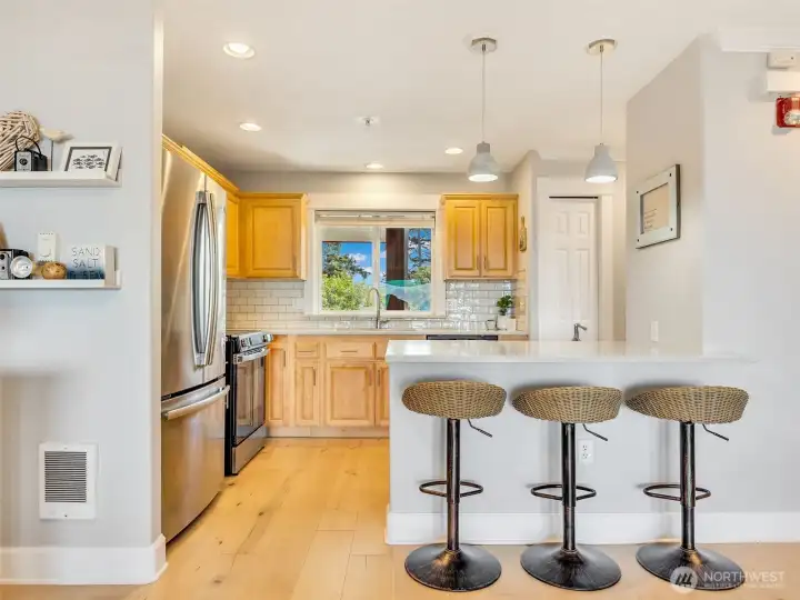 Breakfast bar creates a welcoming gathering space while maintaining the open-concept design.