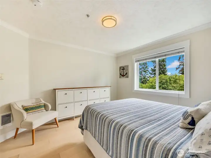 Bright secondary bedroom with large windows and generous closet space, perfect for guests or year-round living.
