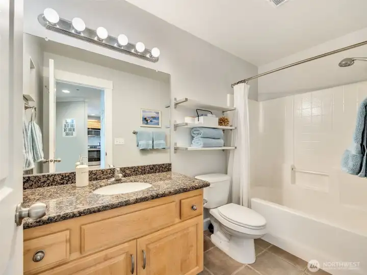 Full guest bathroom featuring a large vanity, tub/shower combination, and convenient access from the guest bedroom and main living area.