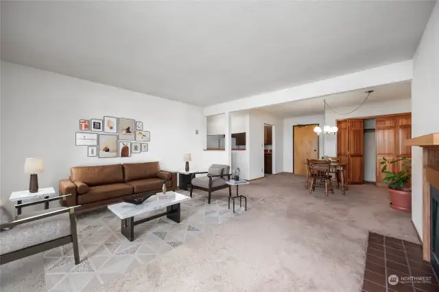 Corner angle by fireplace looking toward kitchen and hallway. Virtually staged living room.