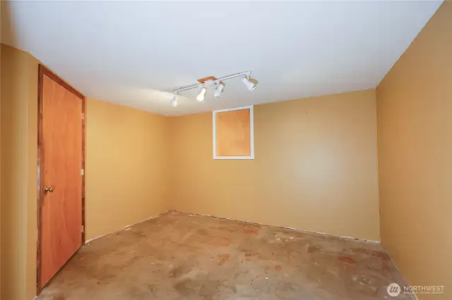 Concrete floor storage area next to garage door.