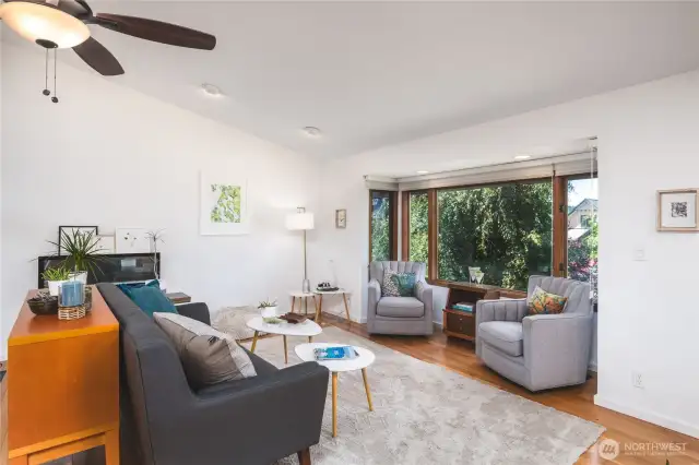 Cozy living room with wood flooring, vaulted ceilings and picture window.