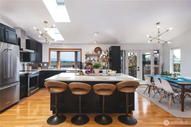 Beautifully updated kitchen with wood floors, large island with eating space, stainless appliances, quartz counters, modern light fixtures. Open to dining room and offering views of the mountains and farmlands.