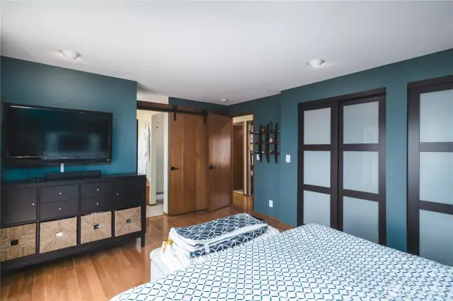 Another view of the primary bedroom with custom paint and closet doors and cute barn doors!