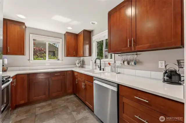 Remodeled kitchen with tile floors, quartz counters & stainless appliances.