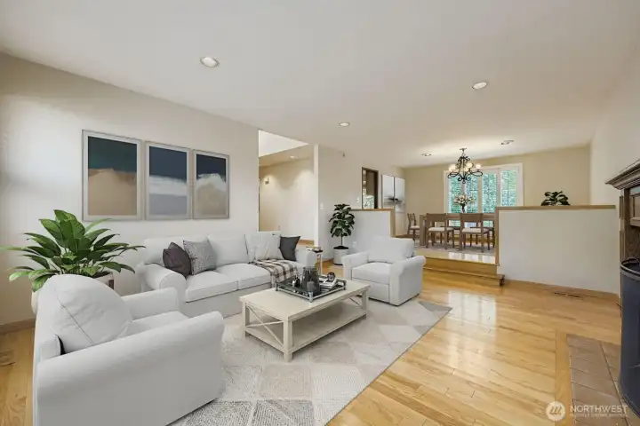 Another view of the sunken living room that steps up to the spacious dining room, all with expansive hardwood floors.