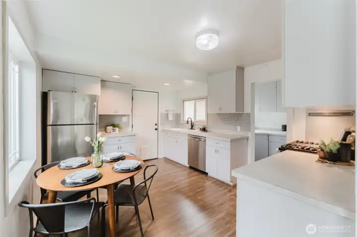 Bright eat-in kitchen with space for dining, newer flooring, and plenty of natural light.