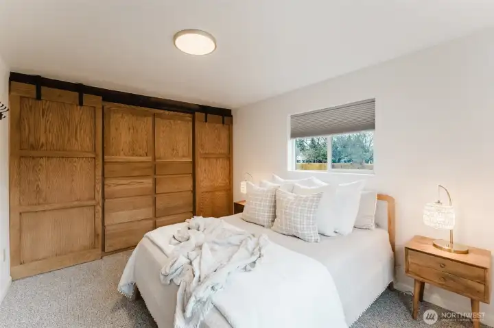 Light-filled primary bedroom featuring a full wall of custom storage for exceptional organization.