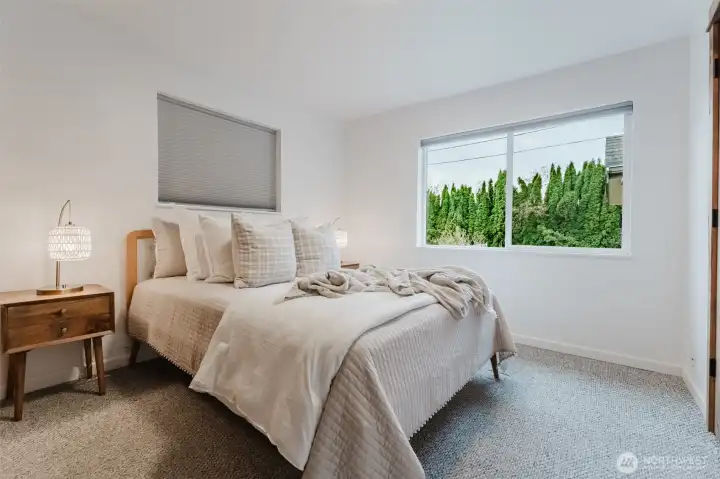 Bright and comfortable primary bedroom with neutral tones and newer windows.