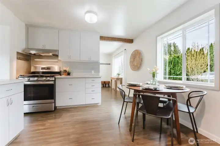 Comfortable dining space with large window, bringing in natural light and views of the surrounding greenery.